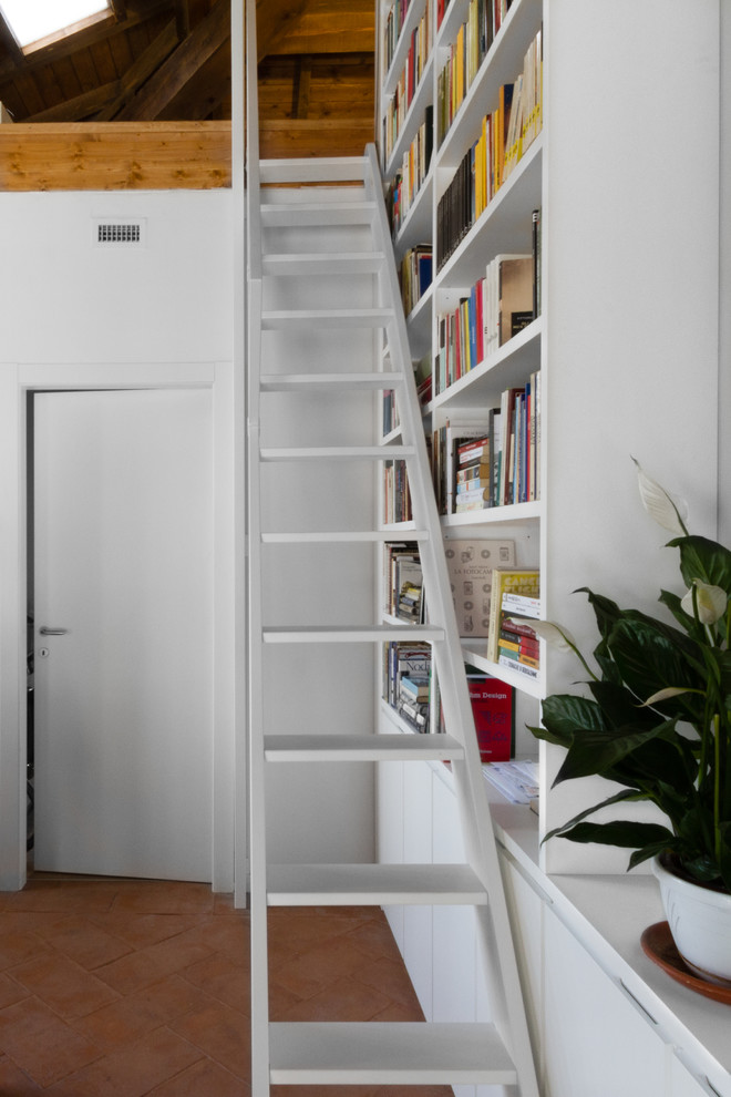 Imagen de escalera recta moderna pequeña con escalones de madera pintada y barandilla de metal