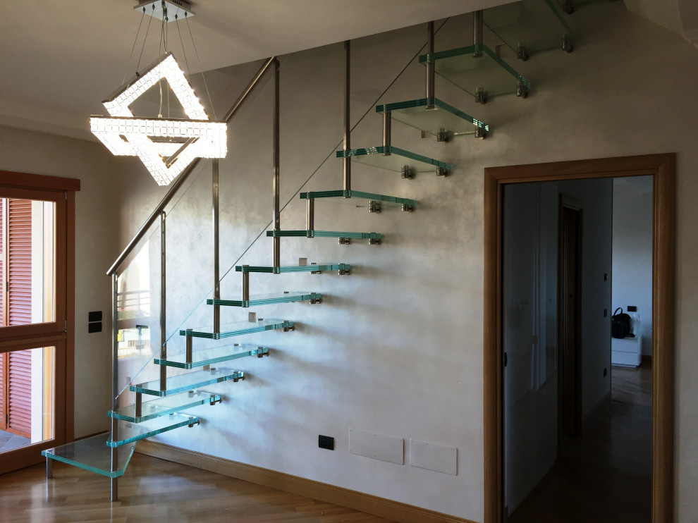 Diseño de escalera en L moderna sin contrahuella con escalones de vidrio y barandilla de varios materiales