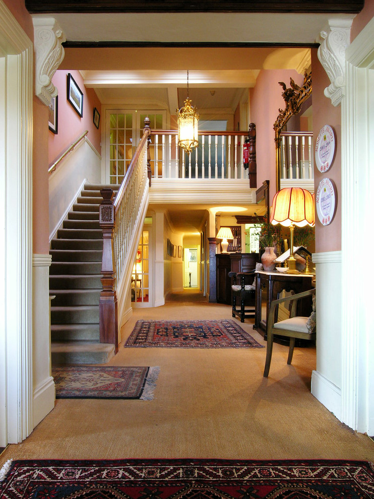 Пример оригинального дизайна: большая прямая лестница в классическом стиле с ступенями с ковровым покрытием