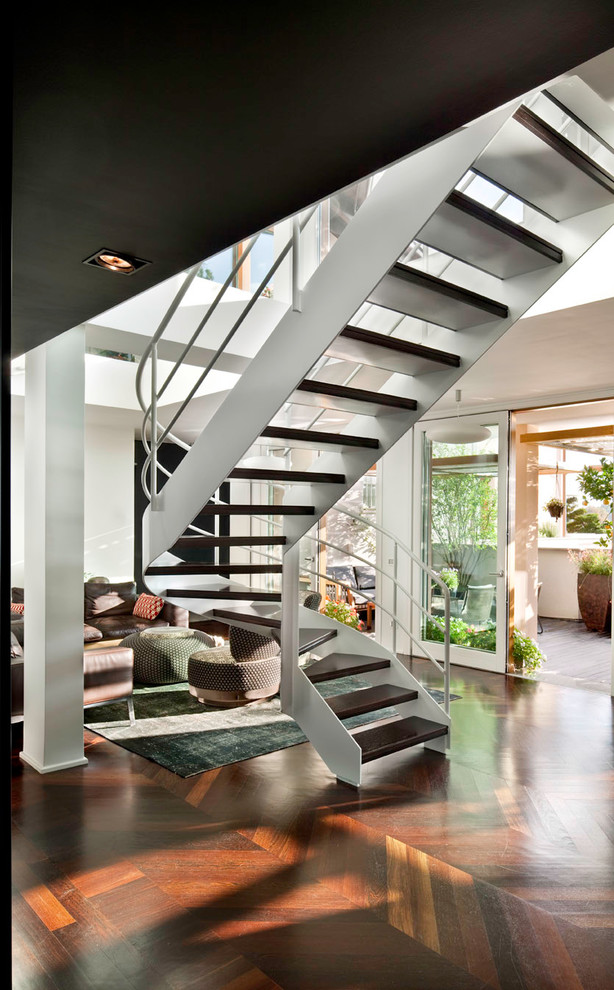 Пример оригинального дизайна: изогнутая лестница среднего размера в современном стиле с деревянными ступенями и металлическими перилами без подступенок