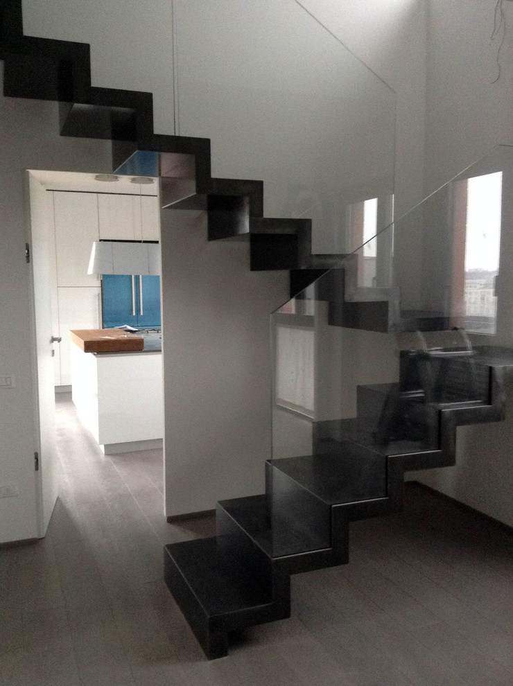 На фото: большая п-образная лестница в стиле модернизм с металлическими ступенями и стеклянными подступенками