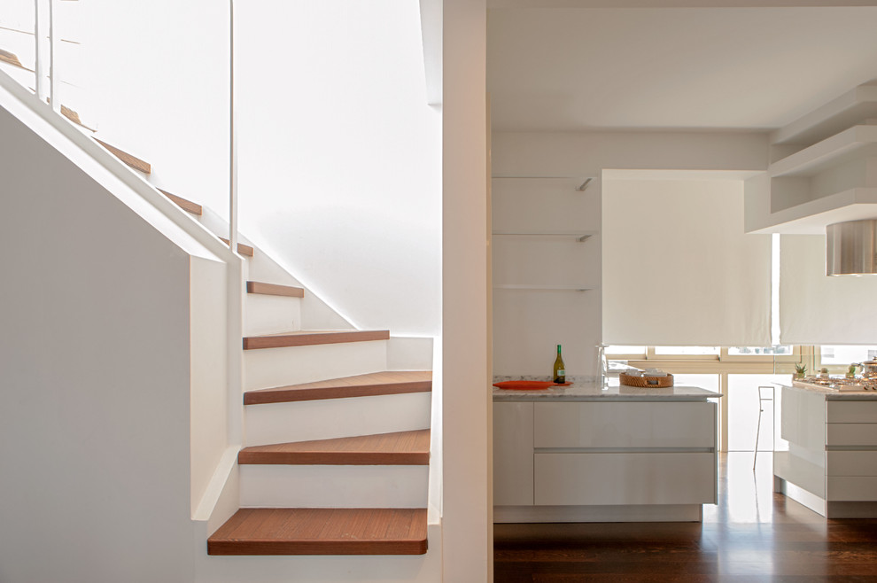 Aménagement d'un grand escalier moderne avec des contremarches en béton, des marches en bois et éclairage.