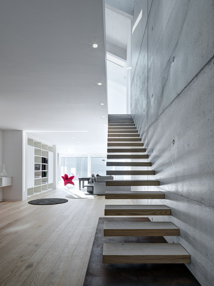 Foto de escalera suspendida minimalista grande sin contrahuella con escalones de madera