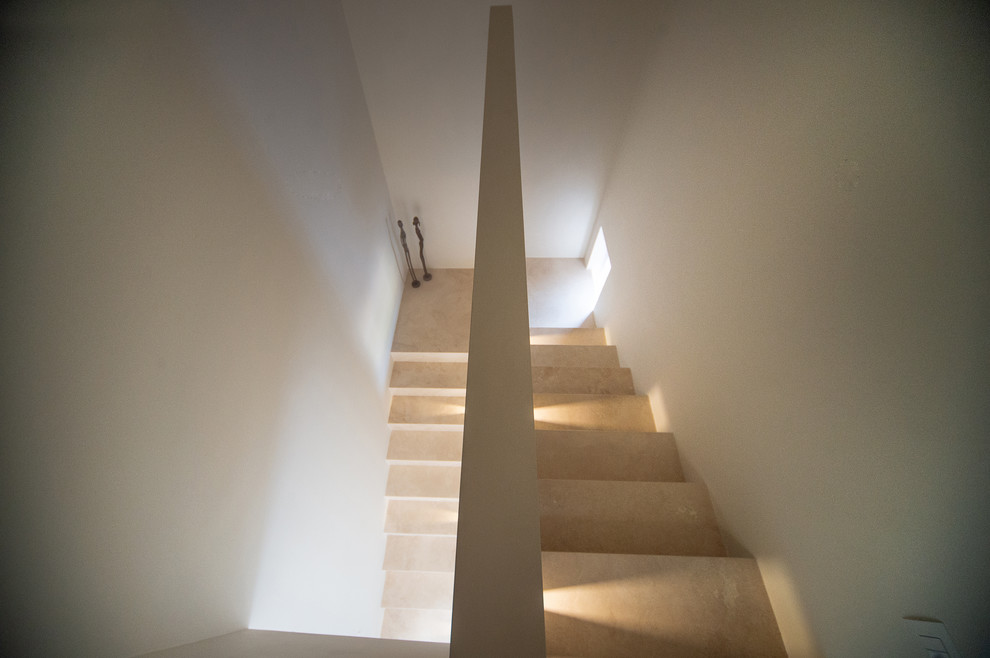 Inspiration pour un escalier design en U de taille moyenne avec des marches en travertin, des contremarches en travertin et un garde-corps en matériaux mixtes.
