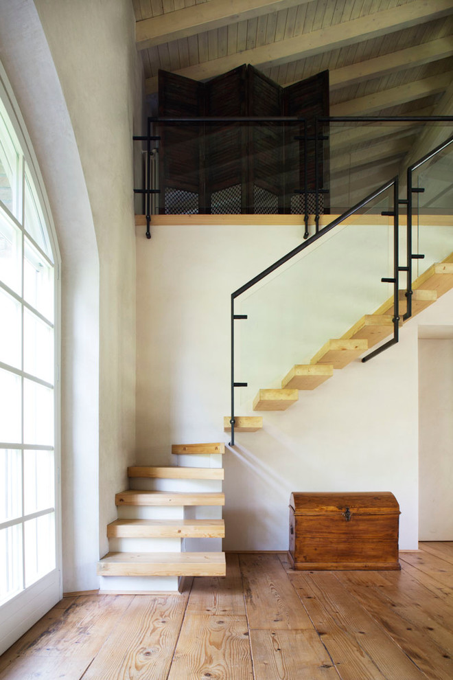 Mediterranean wood l-shaped staircase in Milan with open risers.