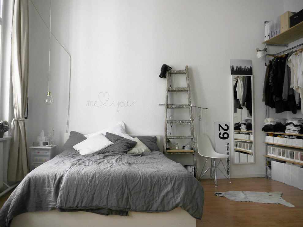 ベルリンにある中くらいなインダストリアルスタイルのおしゃれな主寝室 (白い壁、無垢フローリング、暖炉なし、茶色い床)