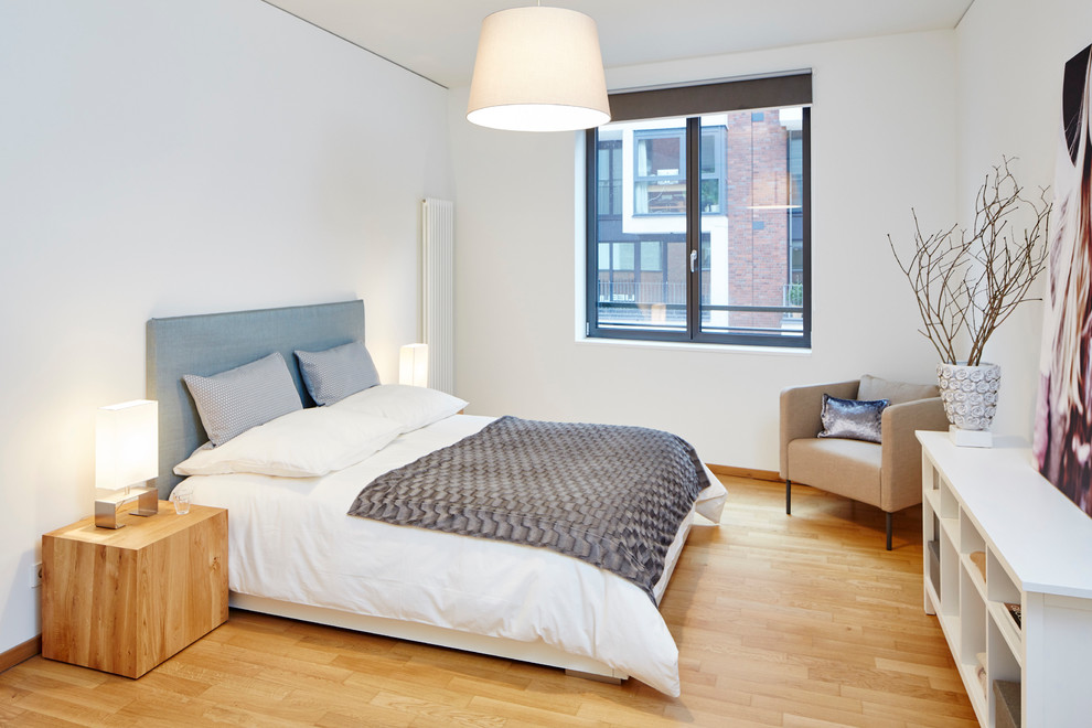 Mittelgroßes Modernes Hauptschlafzimmer ohne Kamin mit weißer Wandfarbe und hellem Holzboden in Hamburg