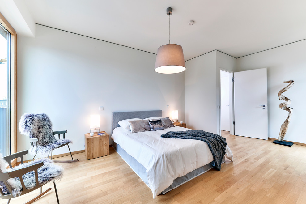 Großes Skandinavisches Hauptschlafzimmer mit grauer Wandfarbe, hellem Holzboden und braunem Boden in Hamburg