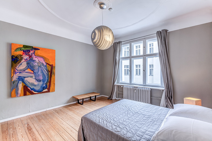 Modernes Schlafzimmer mit grauer Wandfarbe und braunem Holzboden in Berlin