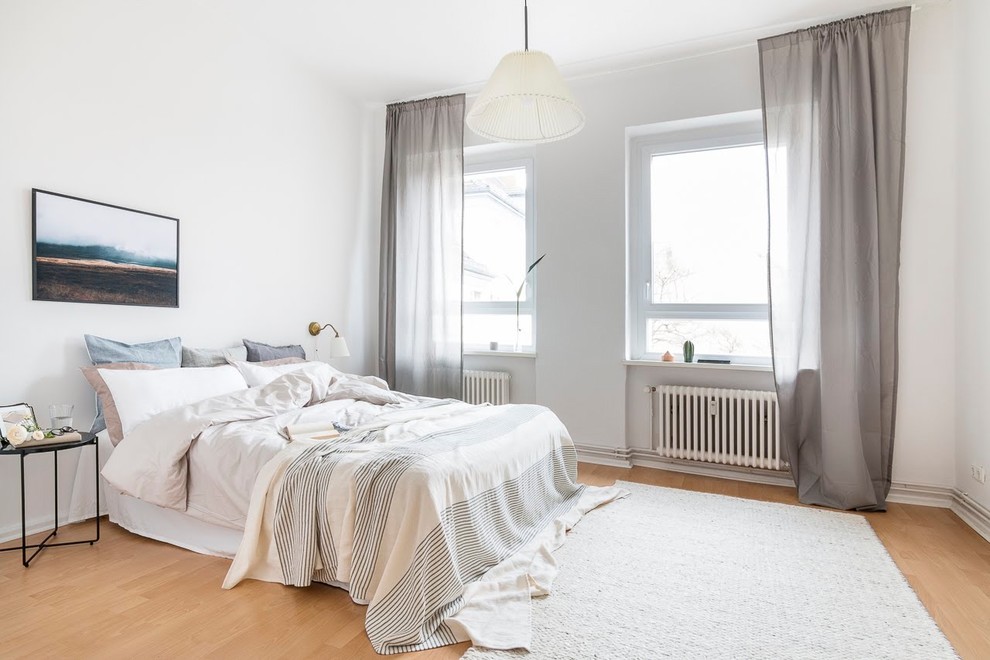 Mittelgroßes Skandinavisches Hauptschlafzimmer ohne Kamin mit weißer Wandfarbe, Laminat und beigem Boden in Berlin