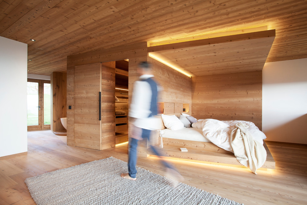 Foto de dormitorio principal contemporáneo con suelo de madera clara