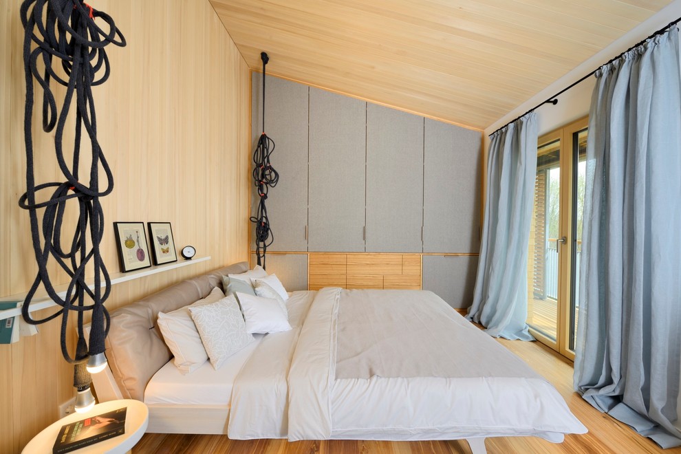 Diseño de dormitorio principal escandinavo de tamaño medio sin chimenea con suelo de madera clara y paredes blancas
