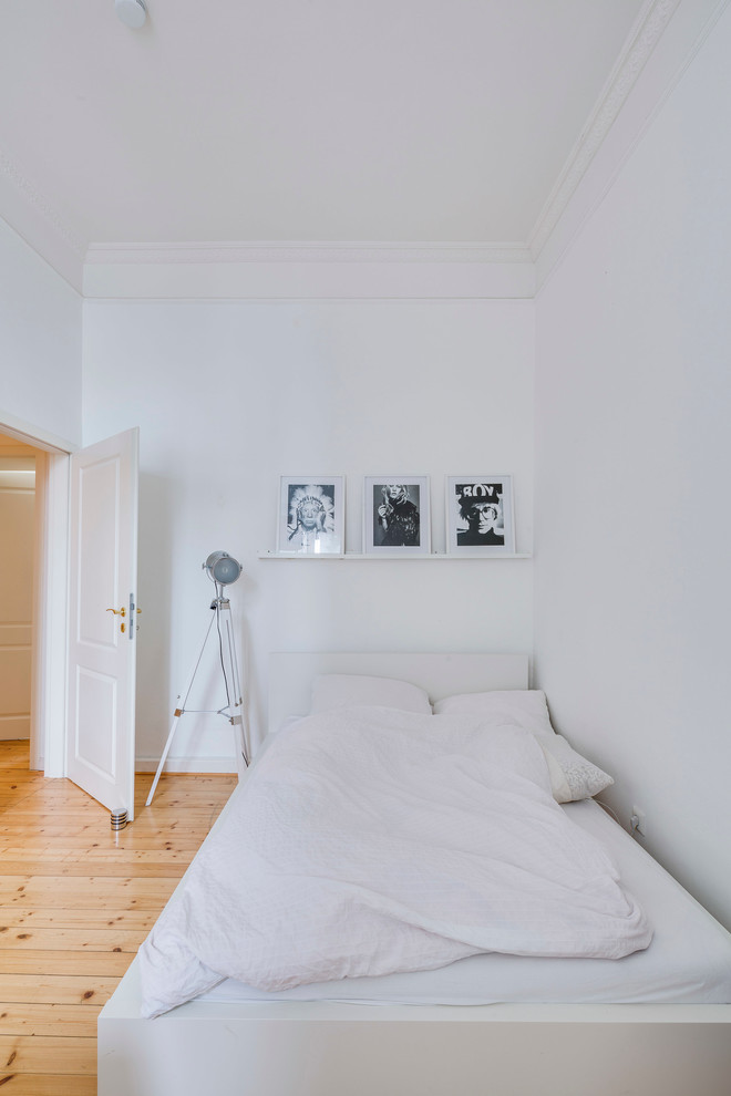 Inspiration for a small scandi bedroom in Cologne with white walls, light hardwood flooring and no fireplace.