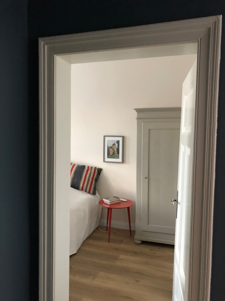 Foto di una camera degli ospiti design di medie dimensioni con pareti grigie e parquet chiaro