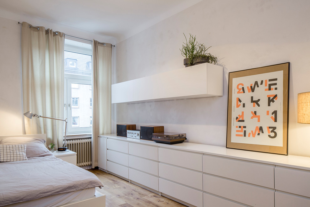 Mittelgroßes Skandinavisches Hauptschlafzimmer ohne Kamin mit beiger Wandfarbe, braunem Holzboden und braunem Boden in Köln