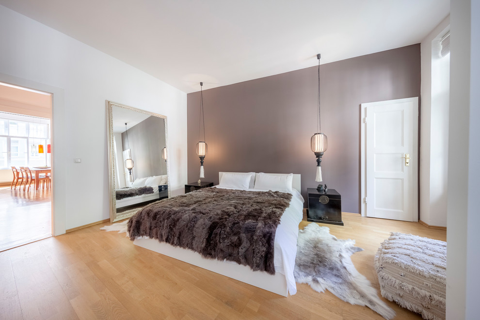 Inspiration for a medium sized contemporary master bedroom in Munich with medium hardwood flooring, brown floors, brown walls and no fireplace.
