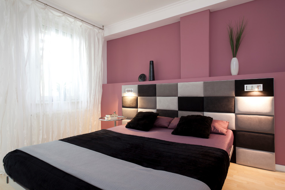 Diseño de dormitorio principal contemporáneo sin chimenea con paredes rosas y suelo de madera clara