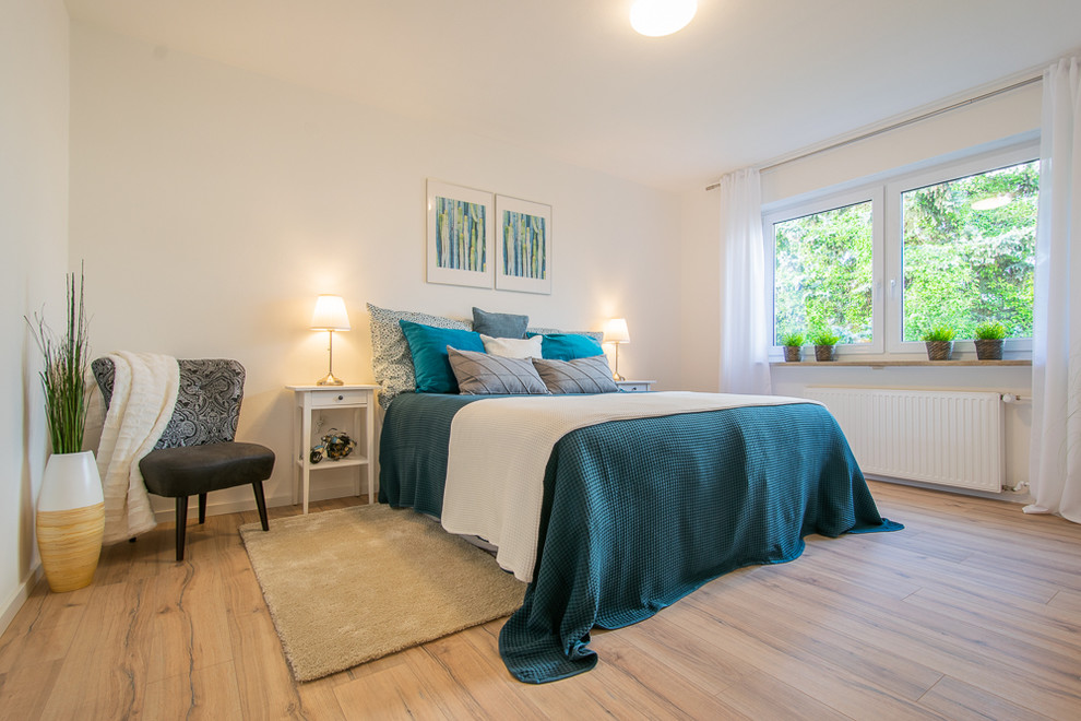 Imagen de dormitorio tradicional renovado con paredes blancas, suelo de madera en tonos medios y suelo marrón