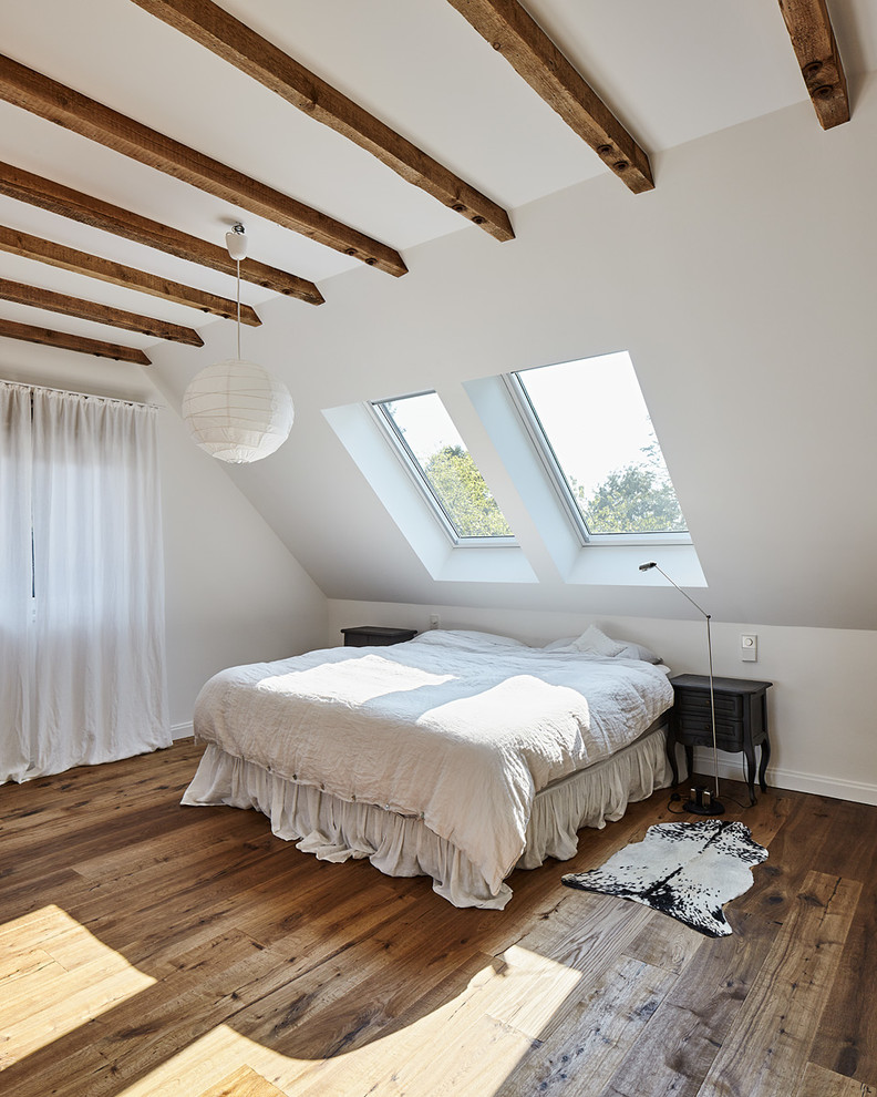 Mittelgroßes Landhausstil Schlafzimmer mit weißer Wandfarbe und dunklem Holzboden in Düsseldorf