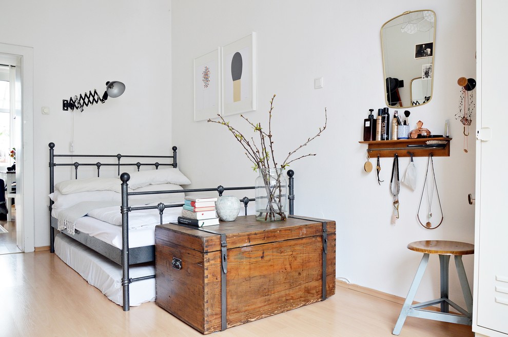 Skandinavisches Hauptschlafzimmer ohne Kamin mit weißer Wandfarbe und hellem Holzboden in Düsseldorf