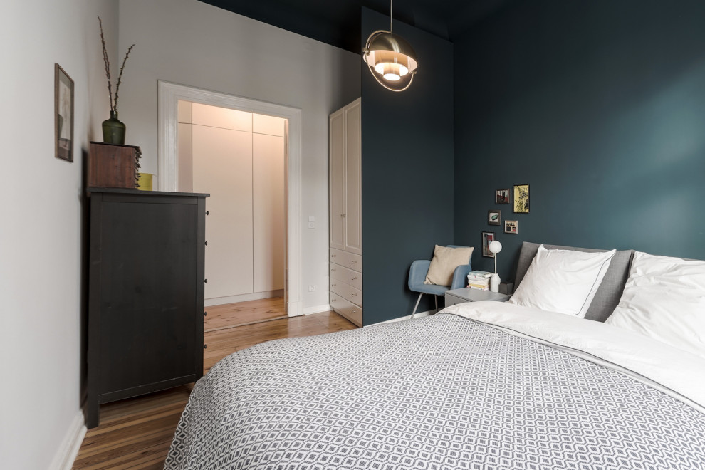 Imagen de dormitorio principal actual pequeño con paredes azules y suelo de madera clara