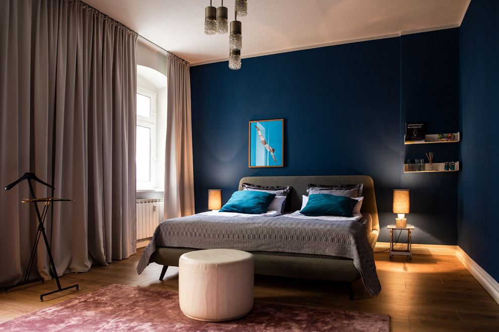 Inspiration för mellanstora eklektiska sovrum, med blå väggar, målat trägolv och brunt golv