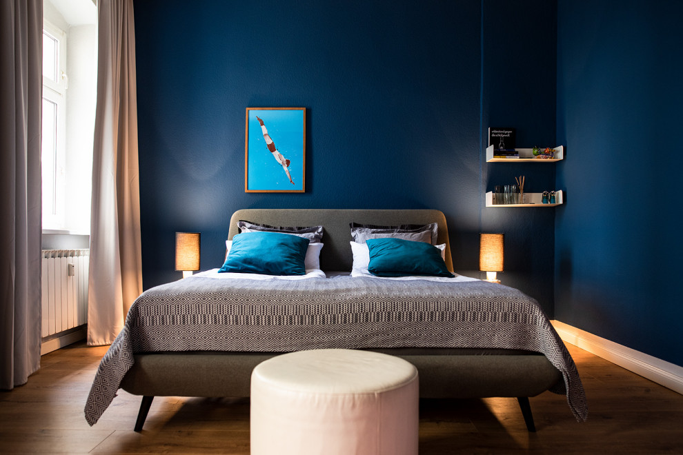 Idee per una camera da letto boho chic di medie dimensioni con pareti blu, pavimento in legno verniciato e pavimento marrone