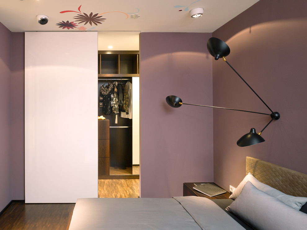 Kleines Modernes Hauptschlafzimmer ohne Kamin mit lila Wandfarbe und dunklem Holzboden in Stuttgart