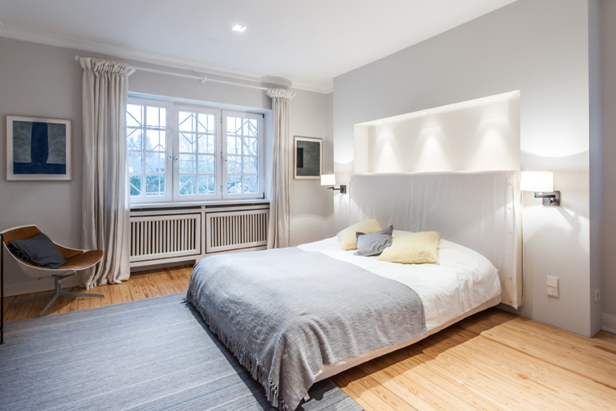 Landhausstil Hauptschlafzimmer mit grauer Wandfarbe und hellem Holzboden in Hamburg