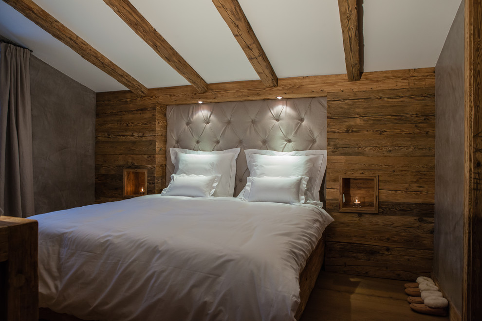 Foto de dormitorio principal rústico pequeño sin chimenea con paredes marrones, suelo de madera en tonos medios y suelo marrón