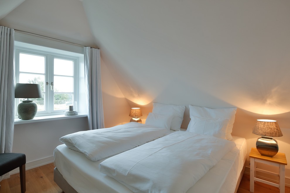 Mittelgroßes Modernes Hauptschlafzimmer ohne Kamin mit weißer Wandfarbe, braunem Holzboden und braunem Boden in München