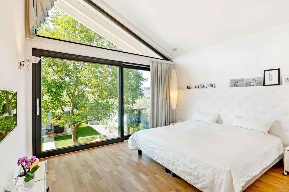 Свежая идея для дизайна: хозяйская спальня среднего размера в современном стиле с белыми стенами, паркетным полом среднего тона и коричневым полом - отличное фото интерьера