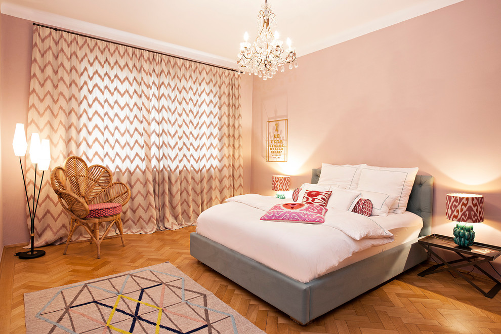 Ejemplo de dormitorio ecléctico grande sin chimenea con paredes rosas y suelo de madera en tonos medios