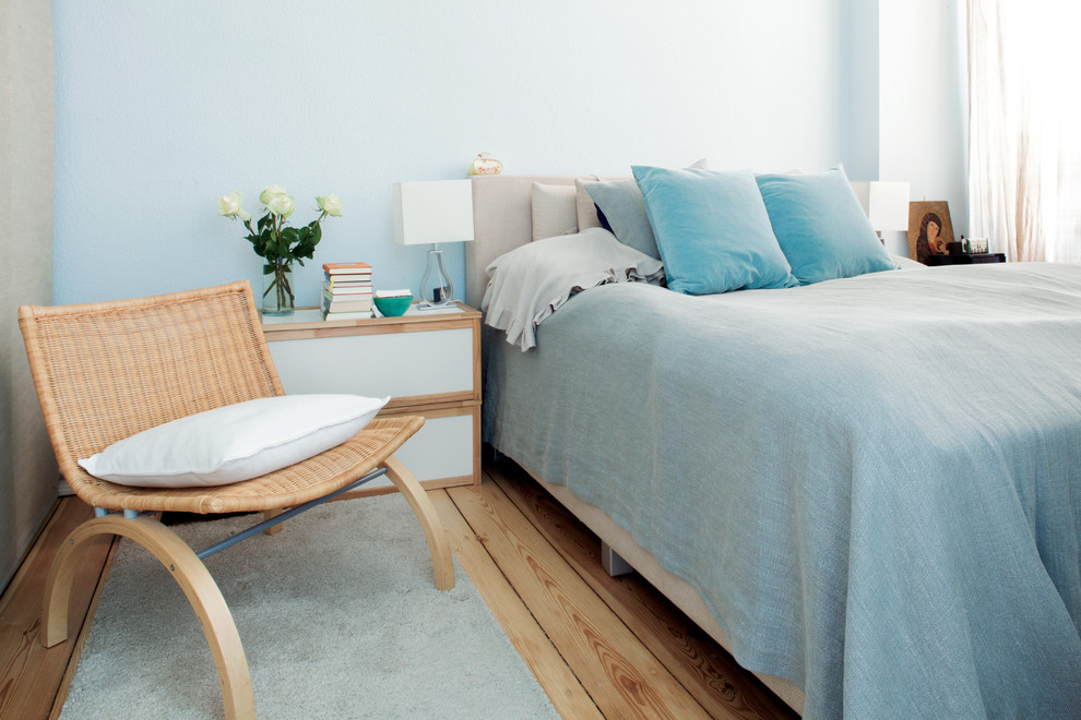 Mittelgroßes Eklektisches Schlafzimmer ohne Kamin mit blauer Wandfarbe und braunem Holzboden in Berlin