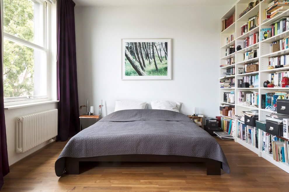 Mittelgroßes Klassisches Hauptschlafzimmer ohne Kamin mit weißer Wandfarbe und braunem Holzboden in Berlin