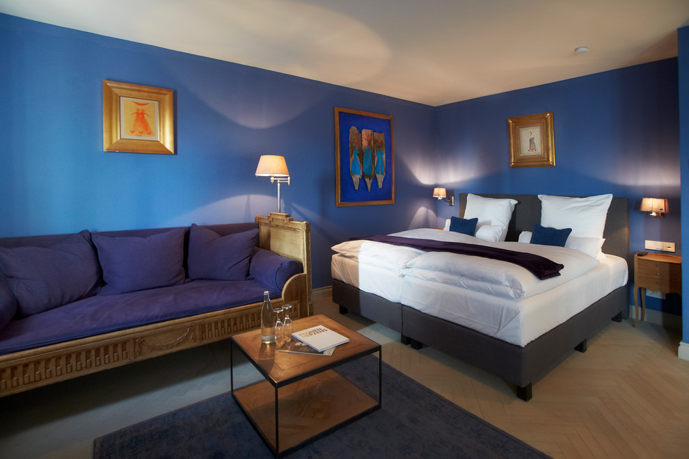 Exempel på ett stort lantligt sovrum, med blå väggar och ljust trägolv