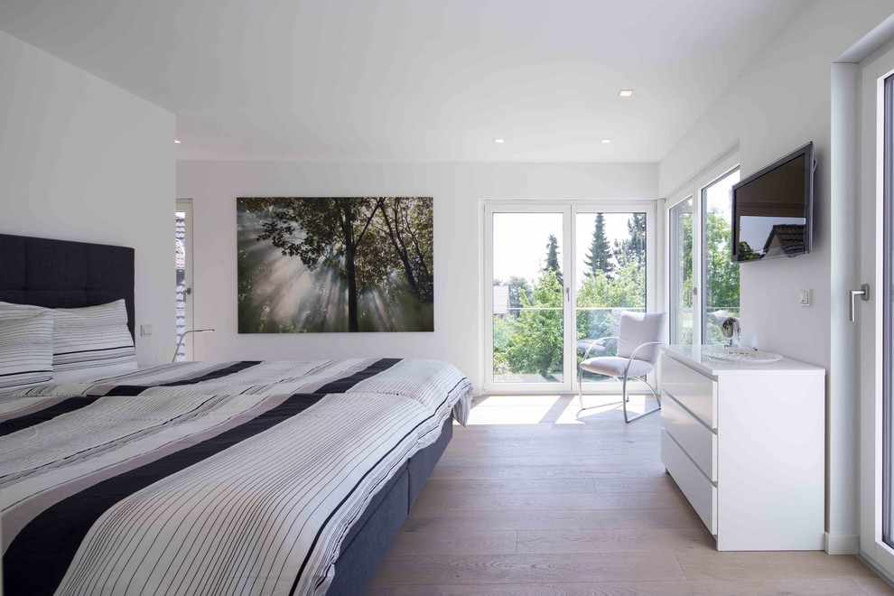 Großes Modernes Hauptschlafzimmer ohne Kamin mit weißer Wandfarbe, hellem Holzboden und braunem Boden in Sonstige