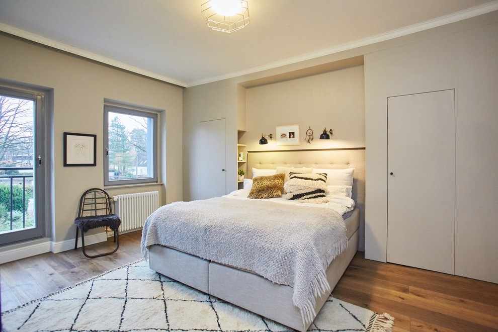 Imagen de dormitorio principal escandinavo extra grande con paredes grises y suelo de madera en tonos medios