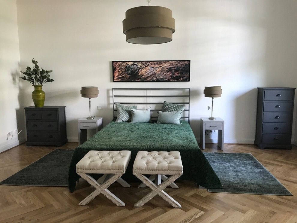 Modelo de dormitorio principal contemporáneo de tamaño medio sin chimenea con paredes blancas, suelo de madera en tonos medios y suelo marrón