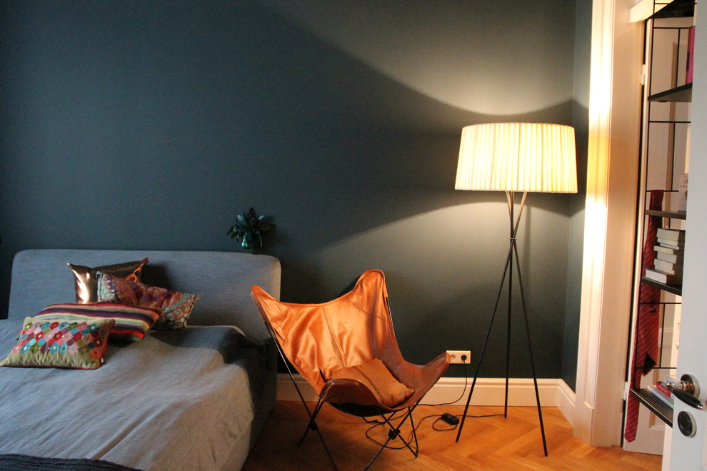 Immagine di una camera matrimoniale bohémian di medie dimensioni con pareti blu, pavimento in legno massello medio e pavimento marrone
