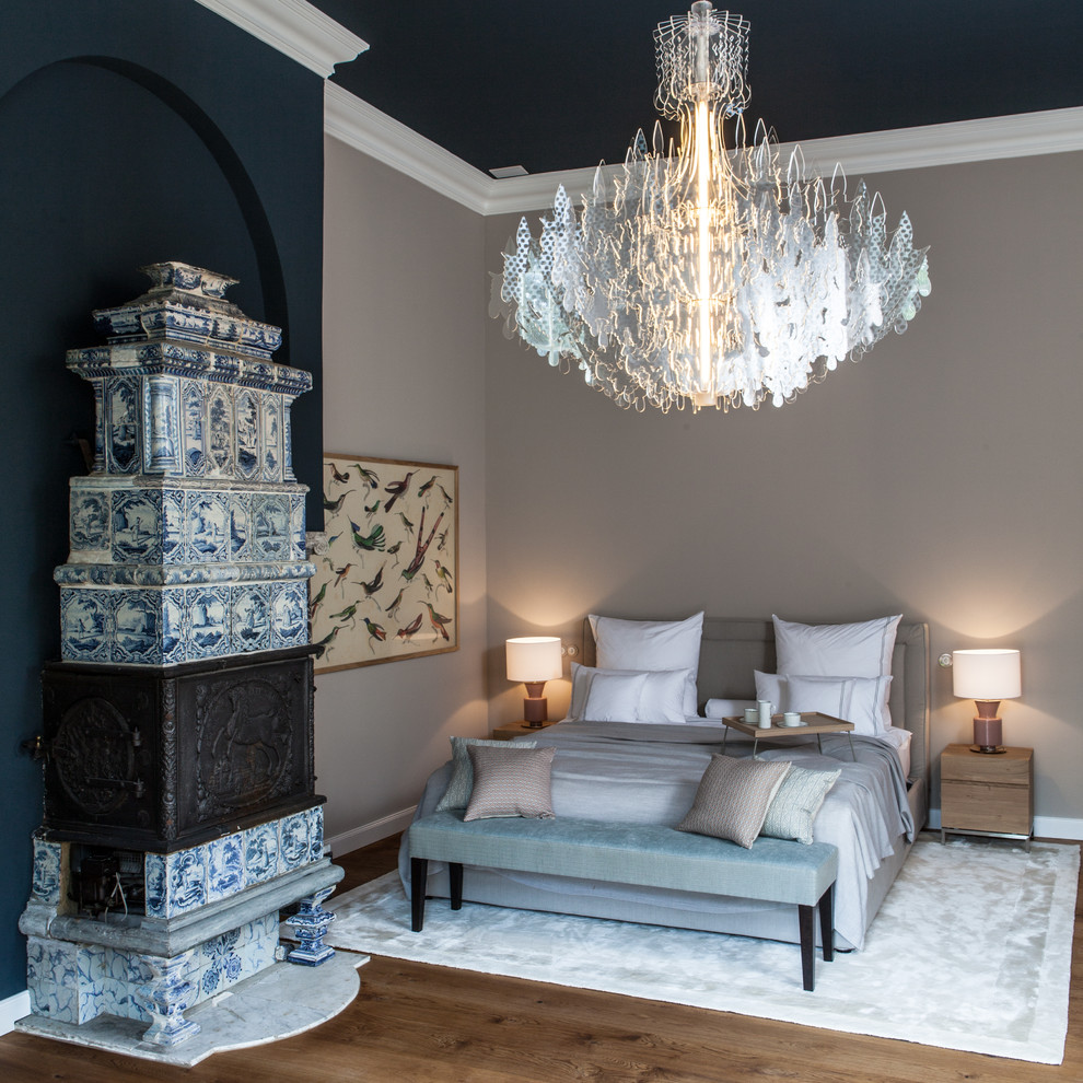 ハンブルクにある巨大なコンテンポラリースタイルのおしゃれな主寝室 (ベージュの壁、無垢フローリング、薪ストーブ、タイルの暖炉まわり、茶色い床) のレイアウト