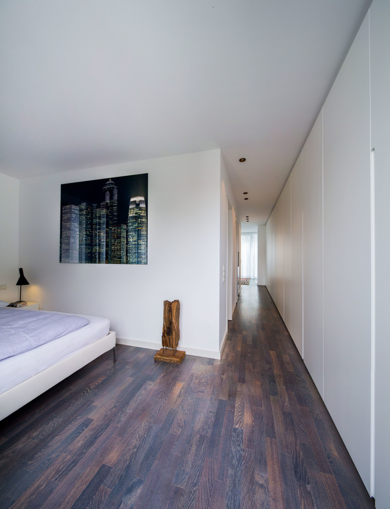Mittelgroßes Modernes Schlafzimmer ohne Kamin mit weißer Wandfarbe und dunklem Holzboden in Frankfurt am Main
