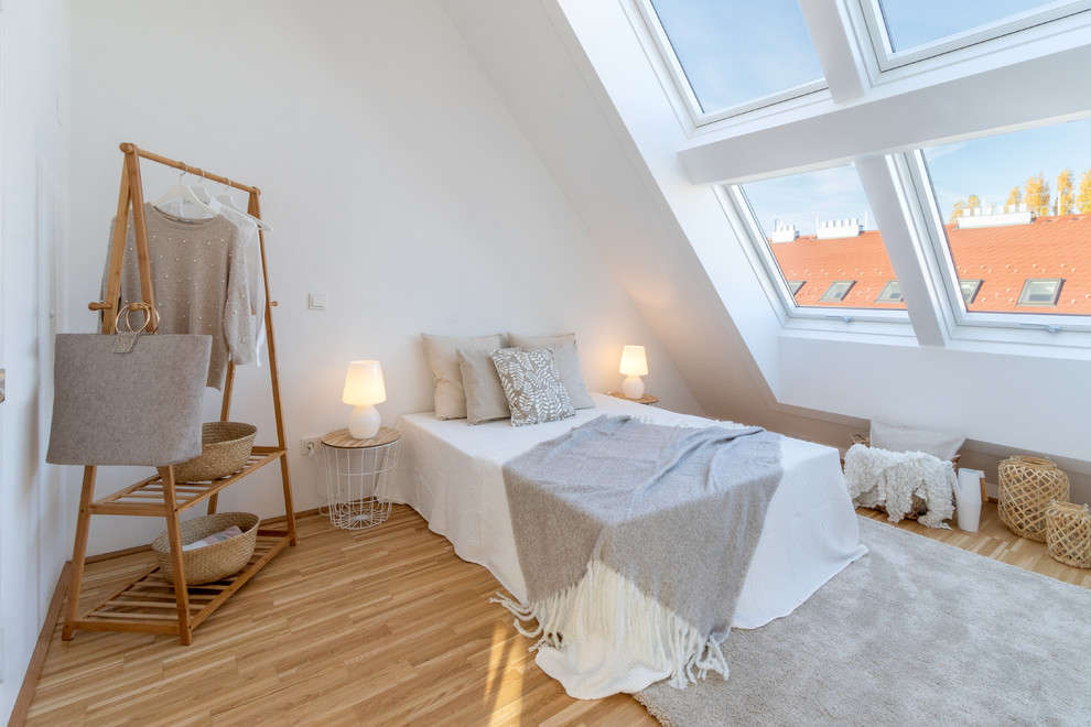 Danish medium tone wood floor and brown floor bedroom photo in Other with white walls
