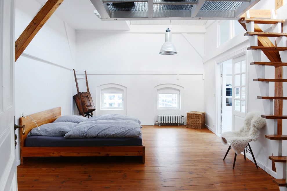 Diseño de dormitorio actual de tamaño medio sin chimenea con paredes blancas y suelo de madera en tonos medios
