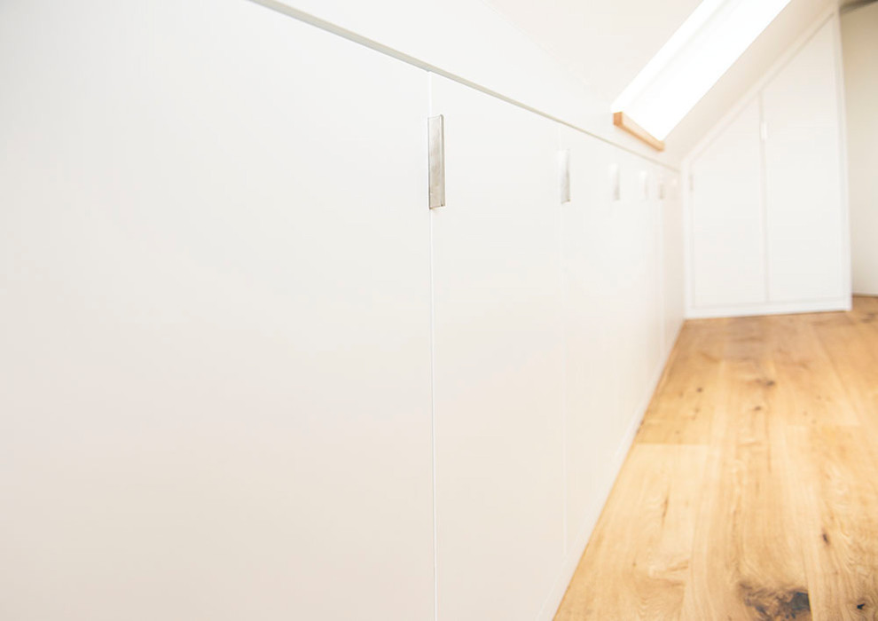 Großes Modernes Hauptschlafzimmer ohne Kamin mit weißer Wandfarbe, braunem Holzboden und braunem Boden in Dortmund