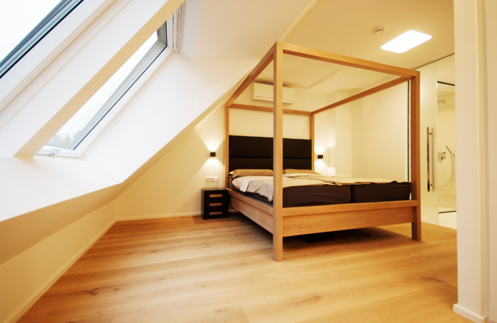 Mittelgroßes Skandinavisches Schlafzimmer mit weißer Wandfarbe, hellem Holzboden und braunem Boden in München