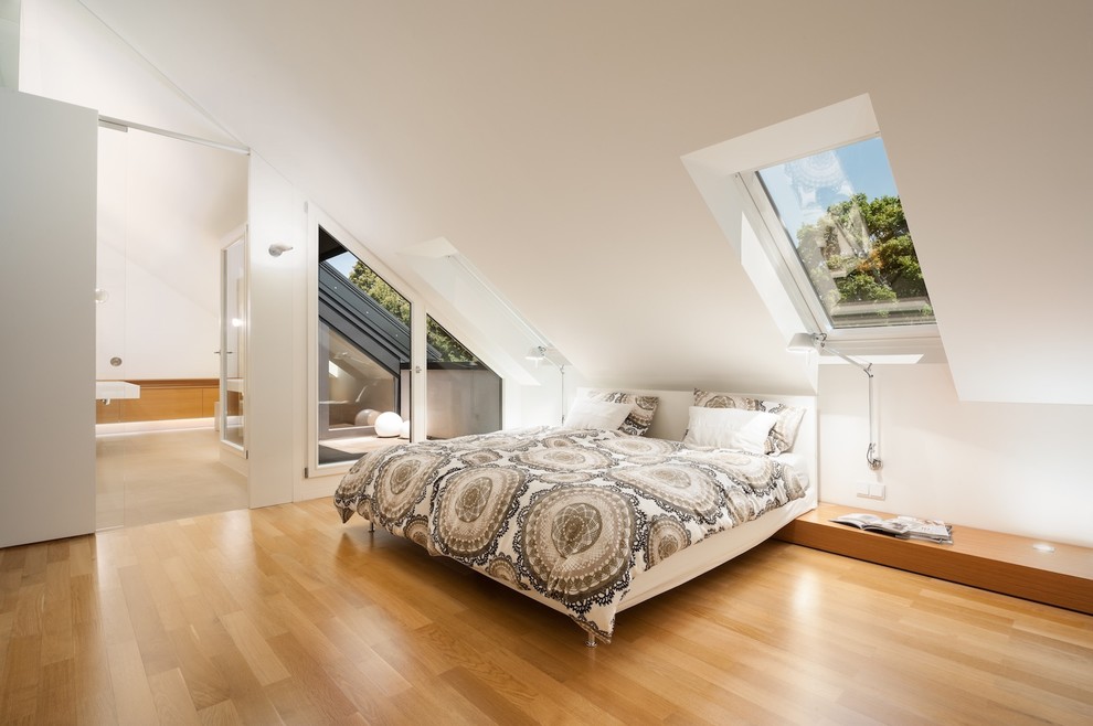 Foto på ett stort funkis sovrum, med vita väggar och mellanmörkt trägolv