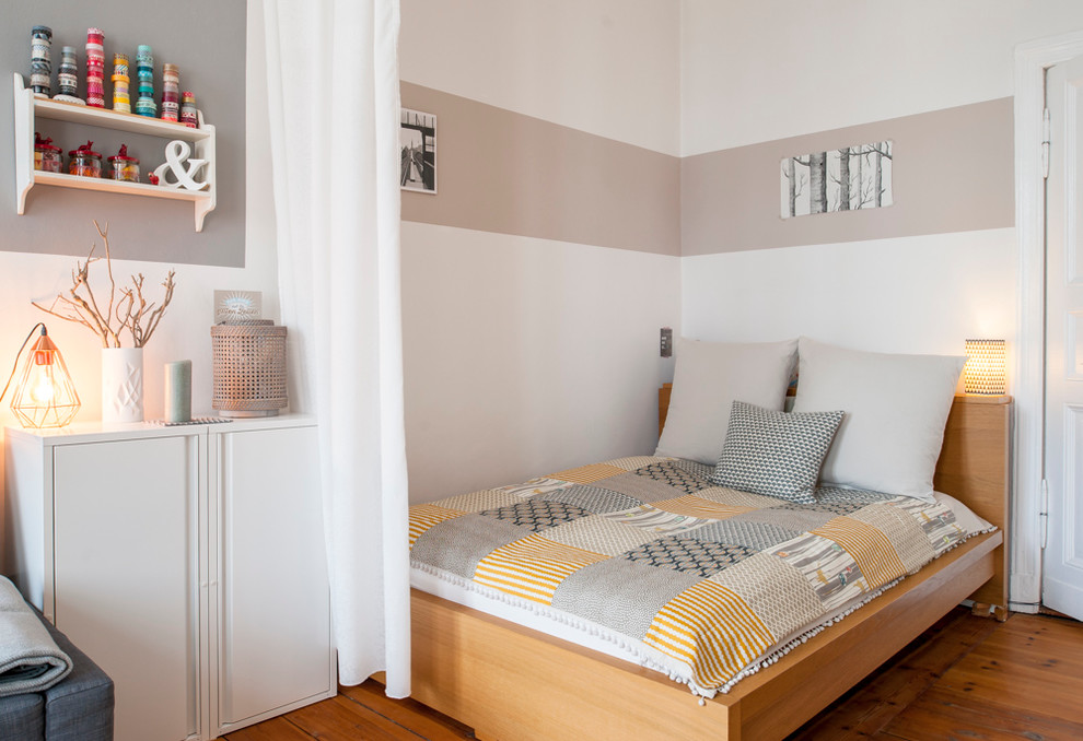 Small scandinavian bedroom in Berlin with light hardwood flooring and white walls.