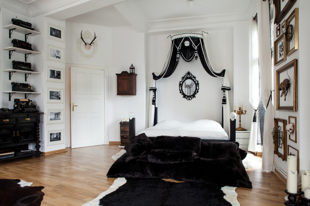 Réalisation d'une très grande chambre parentale bohème avec un mur blanc, un sol en bois brun et aucune cheminée.