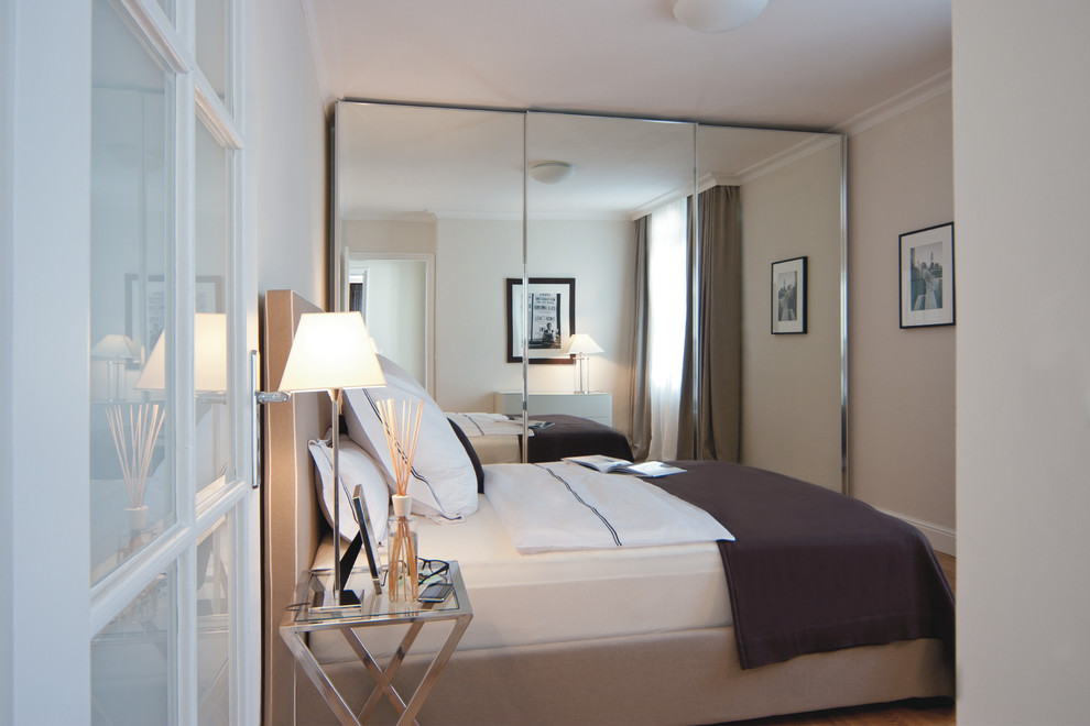 Imagen de dormitorio actual de tamaño medio sin chimenea con paredes beige